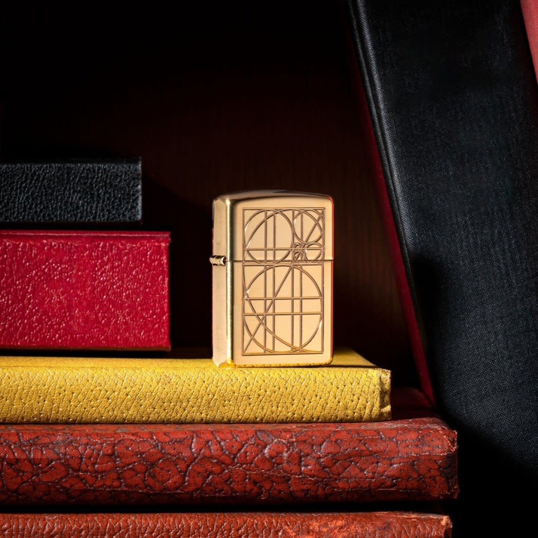 Golden Ratio Armor?« High Polish Brass Windproof Lighter standing on books